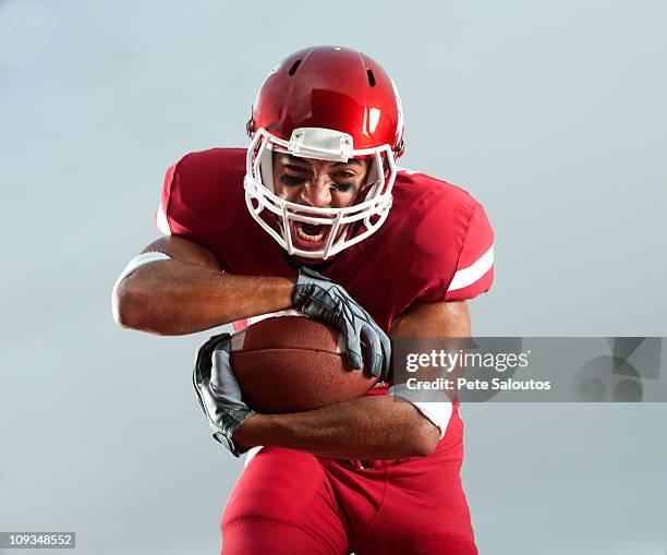 fare le boccacce nero giocatore di football americano palla di trasporto - giocatore di football americano foto e immagini stock