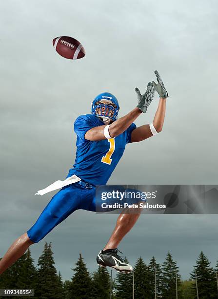 black football player catching football player in mid-air - safety american football player stock pictures, royalty-free photos & images