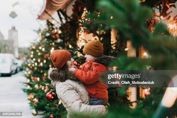 moeder met zoon permanent in de buurt van de kerstboom in rothenburg - kerstmarkt stockfoto's en -beelden