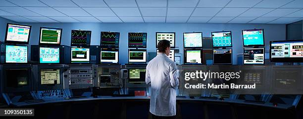 scientist monitoring computers in control room - control centre stock pictures, royalty-free photos & images
