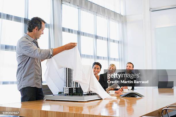 businessman unveiling model building to co-workers - launch event stock pictures, royalty-free photos & images