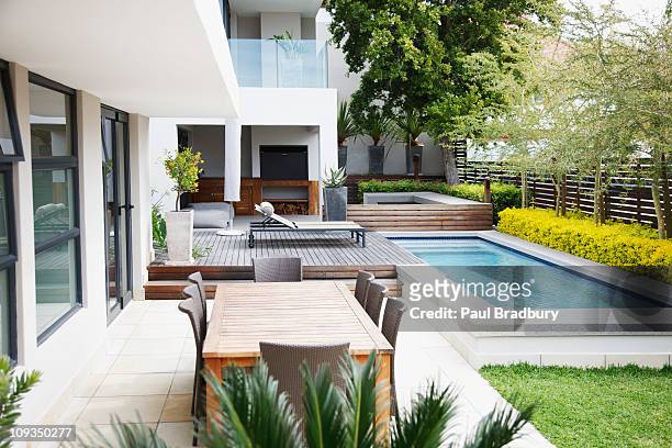 modern patio next to swimming pool - swimming pool stock pictures, royalty-free photos & images