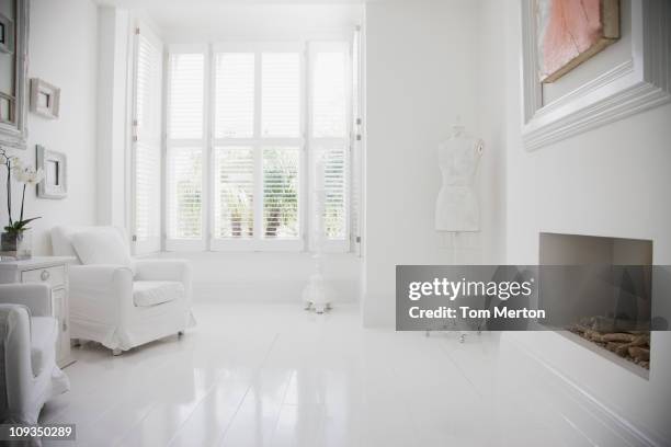 armchairs and fireplace in elegant, white living room - white room stock pictures, royalty-free photos & images