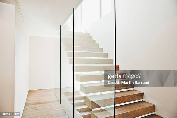 floating staircase and glass walls in modern house - architectuur stockfoto's en -beelden