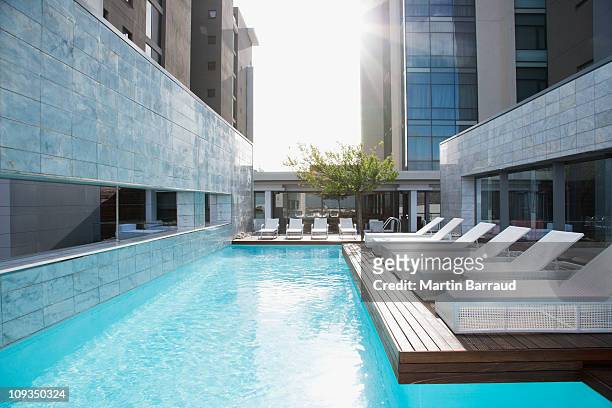 modern lounge chairs next to swimming pool - hotel stock pictures, royalty-free photos & images