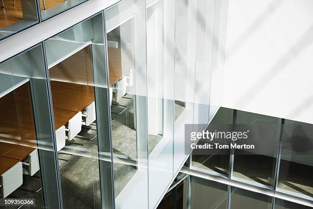 glass walls in atrium of office building - architektur stock-fotos und bilder