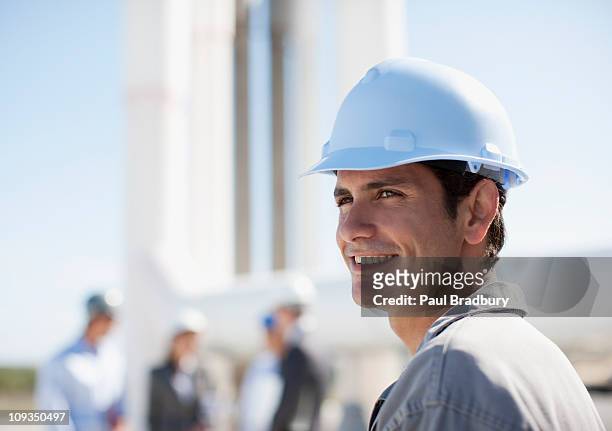 worker in hard-hat standing outdoors - man wearing helmet stock pictures, royalty-free photos & images