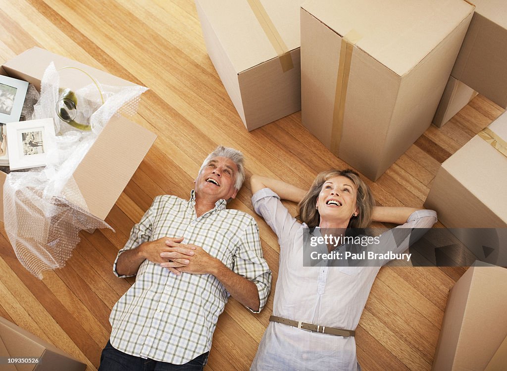 Happy couple laying on floor of new house