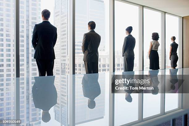 business people looking out conference room window together - indigenous australia stock pictures, royalty-free photos & images