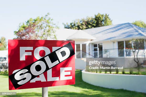 sold sign in front yard of house - house with for sale sign stock-fotos und bilder