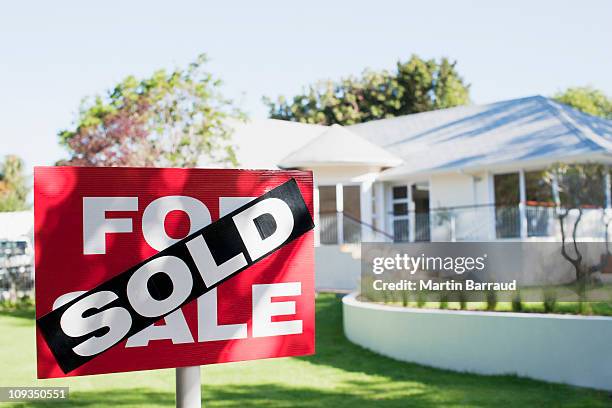 sold sign in front yard of house - ventas fotografías e imágenes de stock