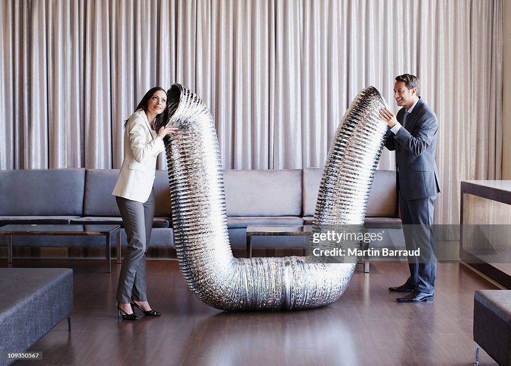 Business people holding metal tubing in hotel lobby