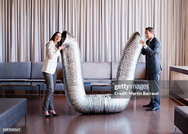 business people holding metal tubing in hotel lobby - interested listener stock pictures, royalty-free photos & images
