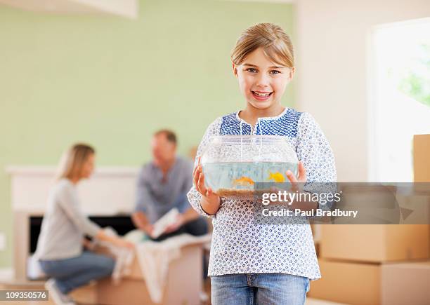 girl holding fish bowl in her new house - goldfish bowl stock pictures, royalty-free photos & images