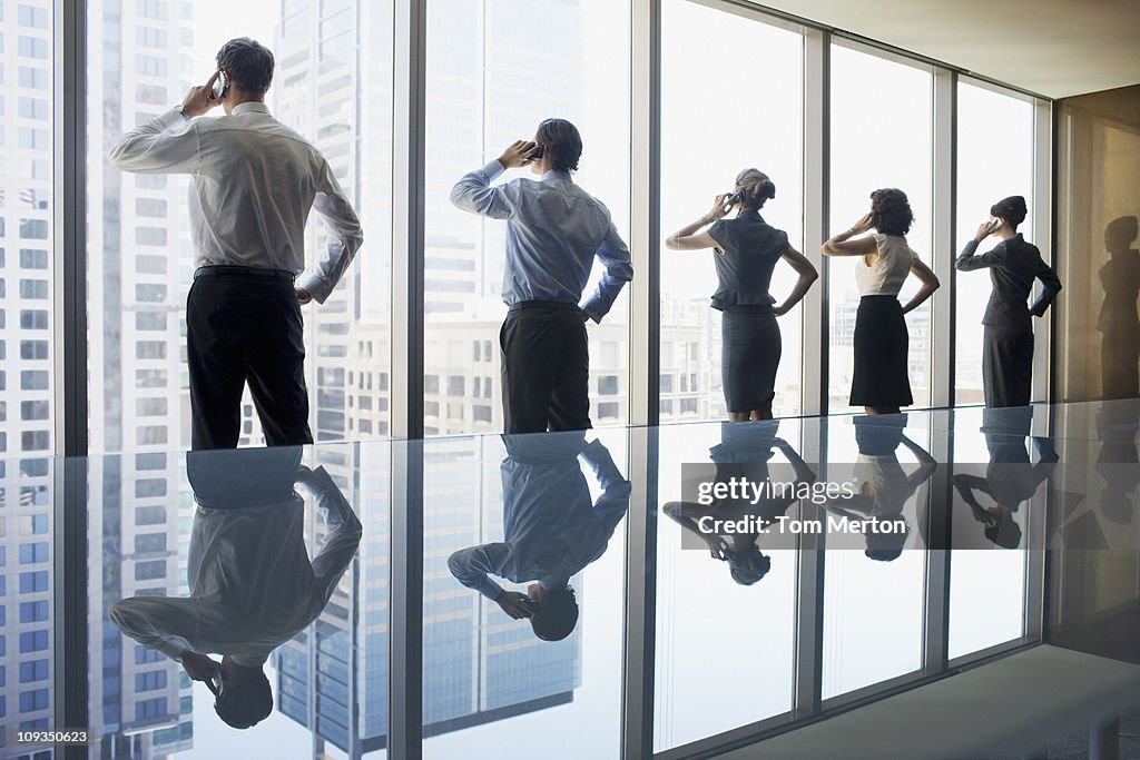 Business people using cell phones in conference room