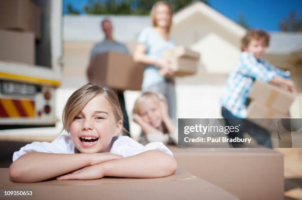 family unloading boxes from moving van - moving truck stock pictures, royalty-free photos & images