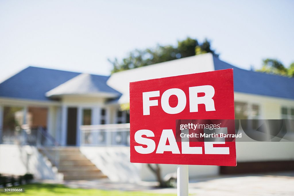 For sale sign in yard of house