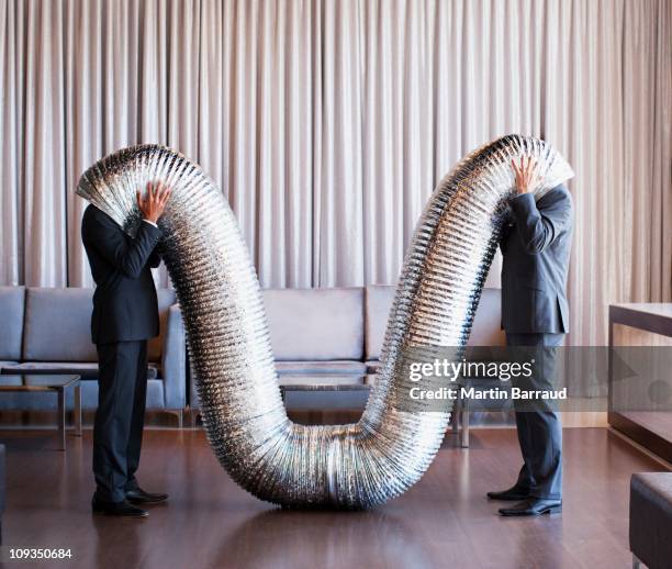 businessmen with their heads inside metal tubing - bizarre humor stock pictures, royalty-free photos & images