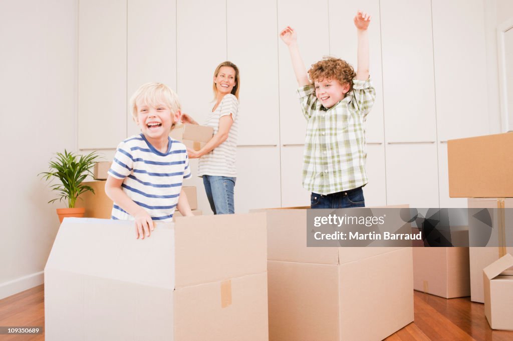 Mother and children unpacking boxes in new house