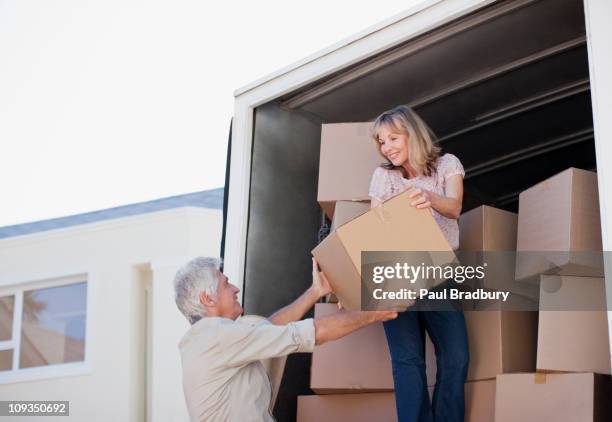 couple unloading boxes from moving van - old moving van stock pictures, royalty-free photos & images