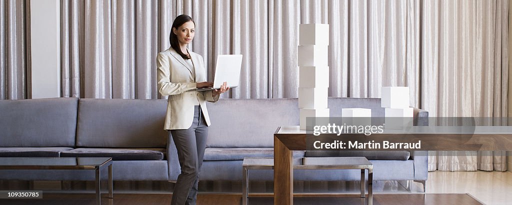 Businesswoman stacking white cubes in hotel lobby