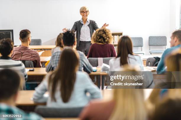 glücklich reife lehrer einen vortrag vor ihren studenten im hörsaal. - professor stock-fotos und bilder