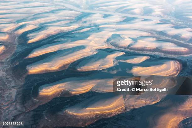 aerial view of the iced earth surface at the arctic at sunset - snow world stock pictures, royalty-free photos & images