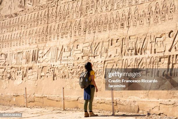 tourist girl admiring medinet habu temple, luxor - hieroglyphics stock pictures, royalty-free photos & images