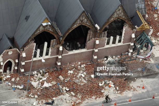 Man rides past a destroyed church on February 23, 2011 in Christchurch, New Zealand. A massive search and rescue mission is underway and least 75...