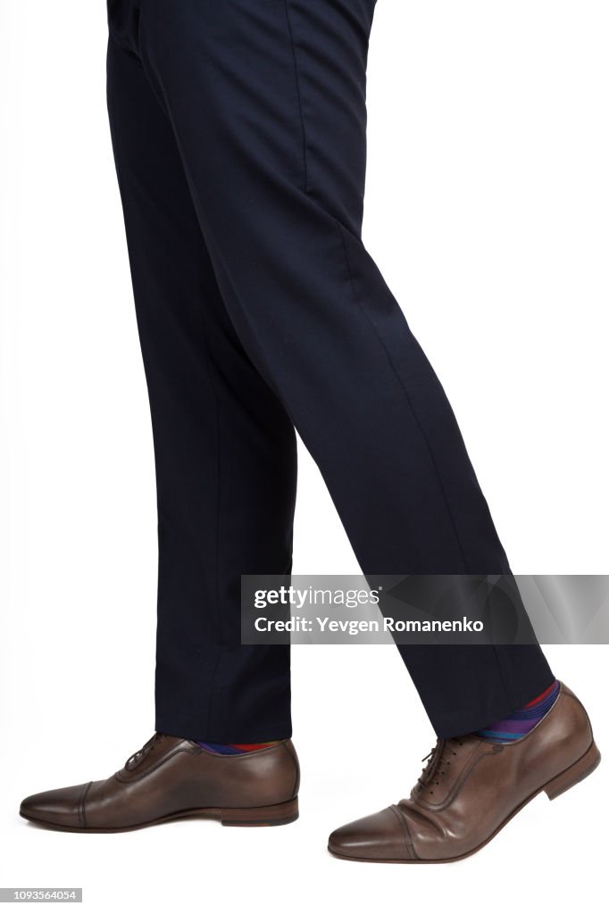 Close-up of man shoes and trousers in walking position isolated on white background