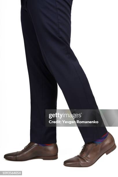 close-up of man shoes and trousers in walking position isolated on white background - black trousers fotografías e imágenes de stock