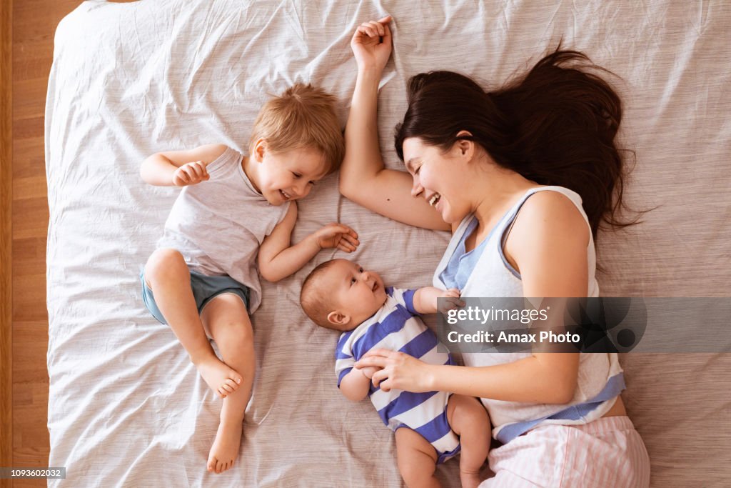 Meninos de duas crianças beijando sua mãe. Retrato de família sorridente feliz de dois close-up