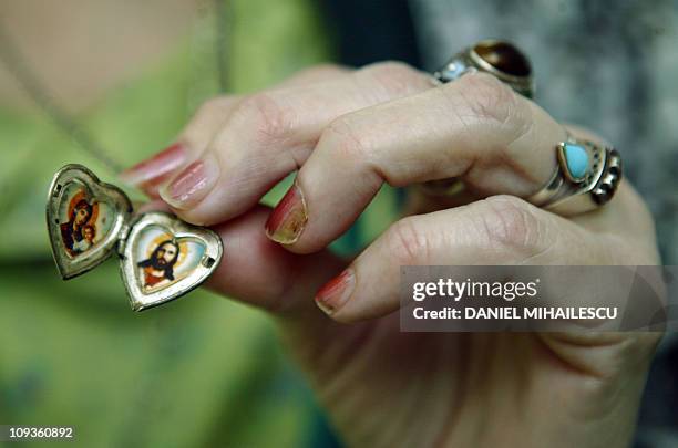 Adriana Iliescu displays her necklace showing The Virgin Mary and Jesus Christ during an interview at the Giulesti Maternity Hospital in Bucharest,...