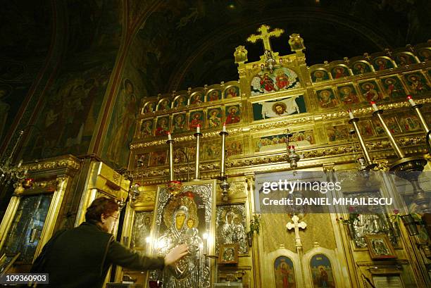 An orthodox believer touches the icon of The Virgin Mary at Saint Basil and Saint Parascheva basilica in Bucharest, 19 January 2005. Adriana Iliescu...