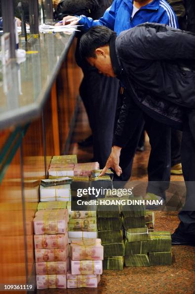 Bricks Banking Note A customer counts bricks of dong bank notes lying on the floor as he ...