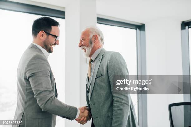 kollegen, die hände schütteln - father son business europe stock-fotos und bilder