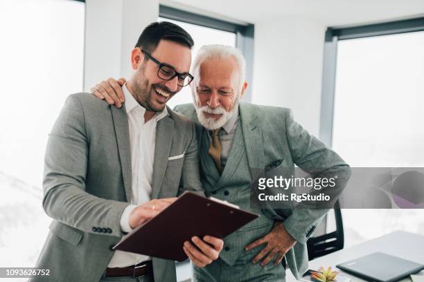 business men looking at documents - family business generations stock pictures, royalty-free photos & images