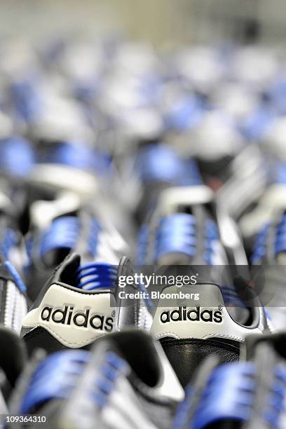 The Adidas AG company logo is displayed on the heels of handmade leather soccer shoes at the company's factory in Scheinfeld, Germany, on Wednesday,...