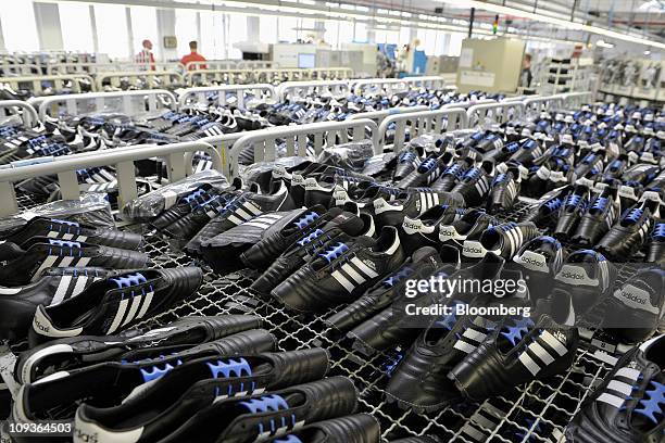 The uppers of Adidas AG soccer shoes sit awaiting completion at the company's factory in Scheinfeld, Germany, on Wednesday, Feb. 23, 2011. Adidas AG...