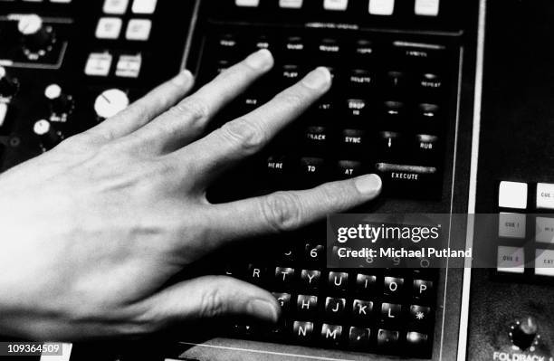 The hand of record producer T-Bone Burnett, programming the automation section of a recording studio mixing desk, Dublin, Ireland, May 1988.