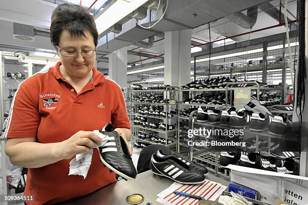 Employee Erika Lassel examines finished soccer shoes at the final inspection area at the Adidas AG factory in Scheinfeld, Germany, on Wednesday, Feb....
