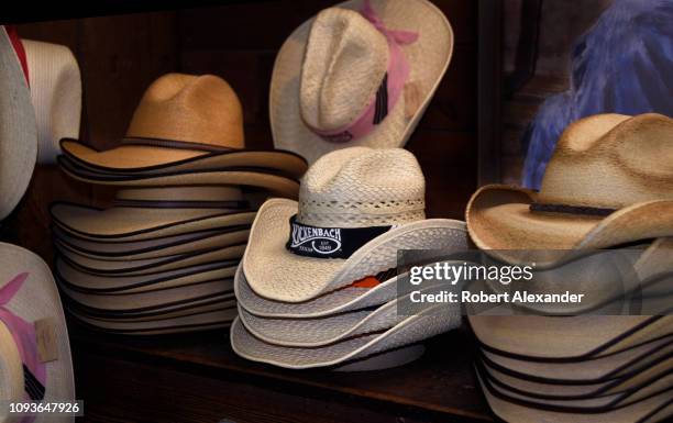 Variety of souvenir straw cowboy hats for sale in the general store in Luckenbach, Texas, a tourist attraction and popular country music venue near...