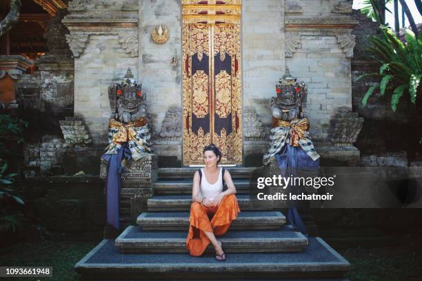 young tourist woman relaxing by the balinese temple - bali temples stock pictures, royalty-free photos & images