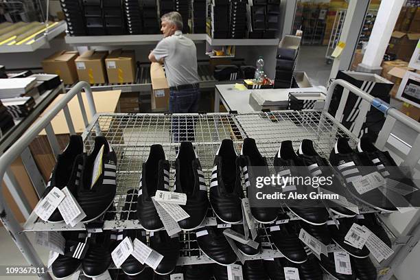 Handcrafted football boots stand in a rack at the factory of German sporting-goods maker Adidas AG on February 23, 2011 in Scheinfeld, Germany. The...