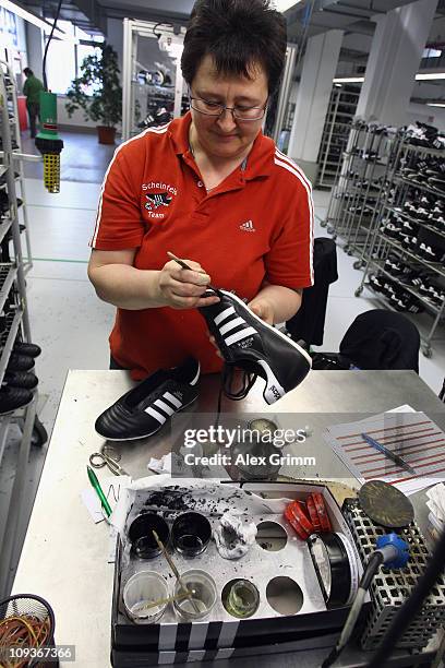 Employee Erika Lassel examines football boots at the final check of the factory of German sporting-goods maker Adidas AG on February 23, 2011 in...