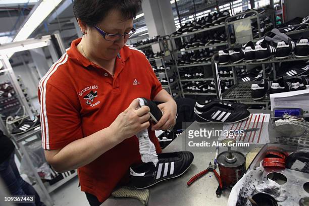 Employee Erika Lassel examines football boots at the final check of the factory of German sporting-goods maker Adidas AG on February 23, 2011 in...