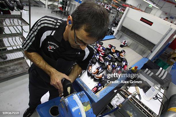 Employee Ingo Meixner removes excrescent glue from a handmade football boot at the factory of German sporting-goods maker Adidas AG on February 23,...