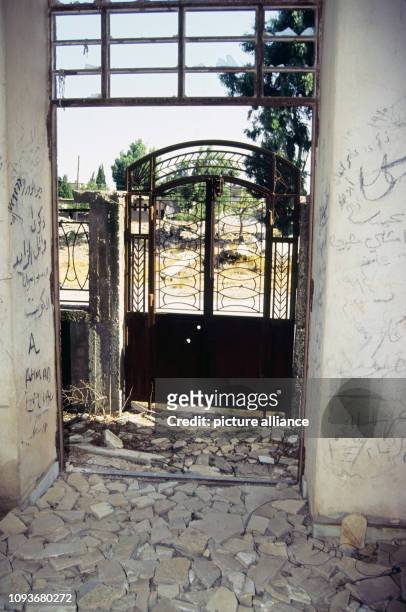 Hauspforte mit zerstörtem Eingangsbereich in der syrischen Grenzstadt Qunaitra auf den Golanhöhen, aufgenommen am . Heute fungiert Qunaitra als eine...