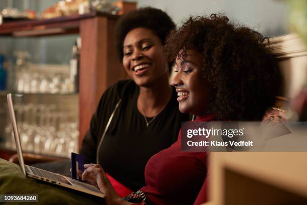 young women ordering christmas gifts online with creditcard - home shopping stock pictures, royalty-free photos & images