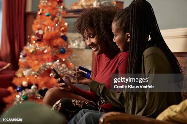 young women ordering christmas gifts online with creditcard - shopping friends family stock pictures, royalty-free photos & images